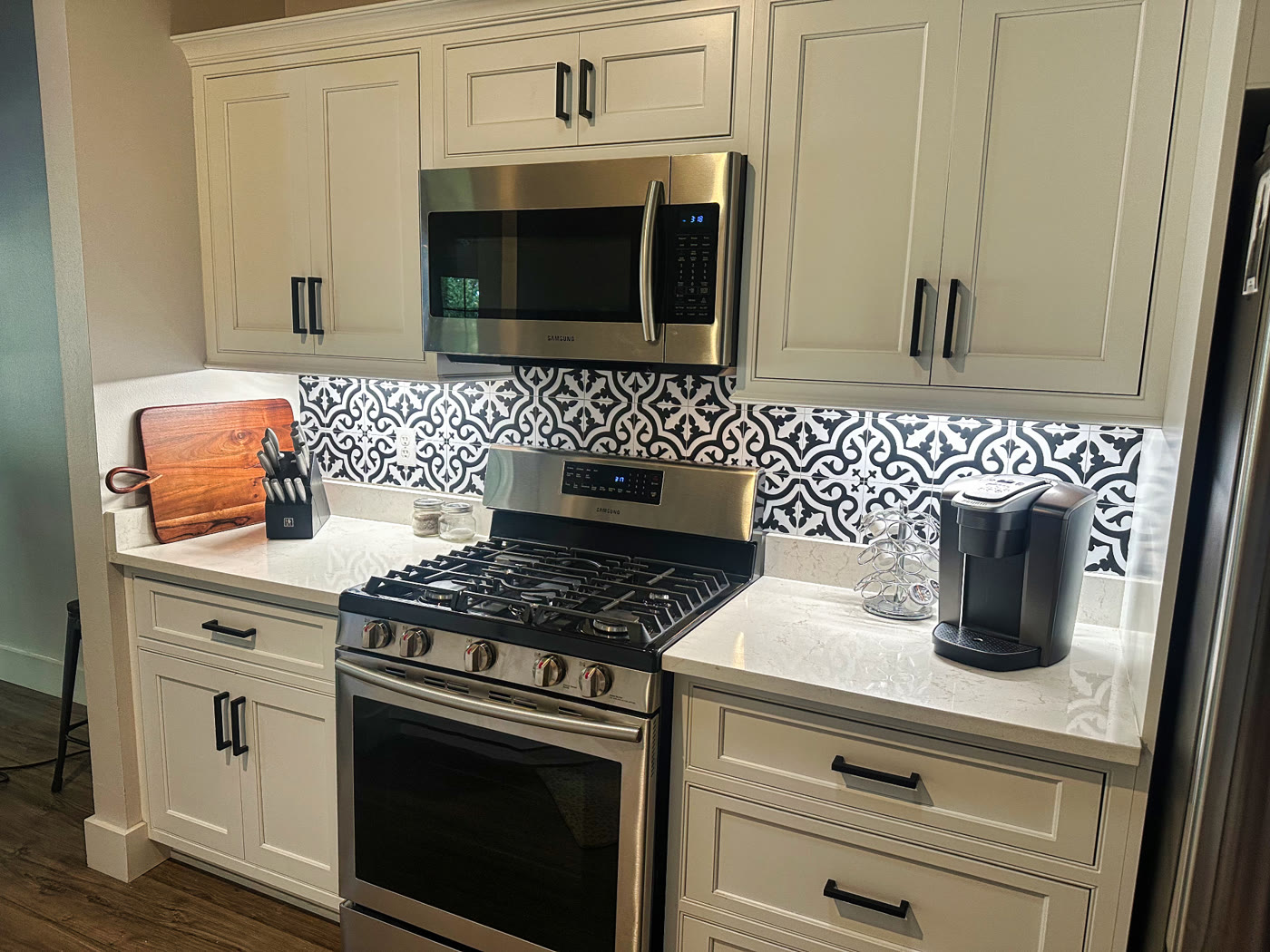 Refinished white kitchen cabinets with black hardware in a Windover Farms home in Melbourne, FL by Launch Painting Co.