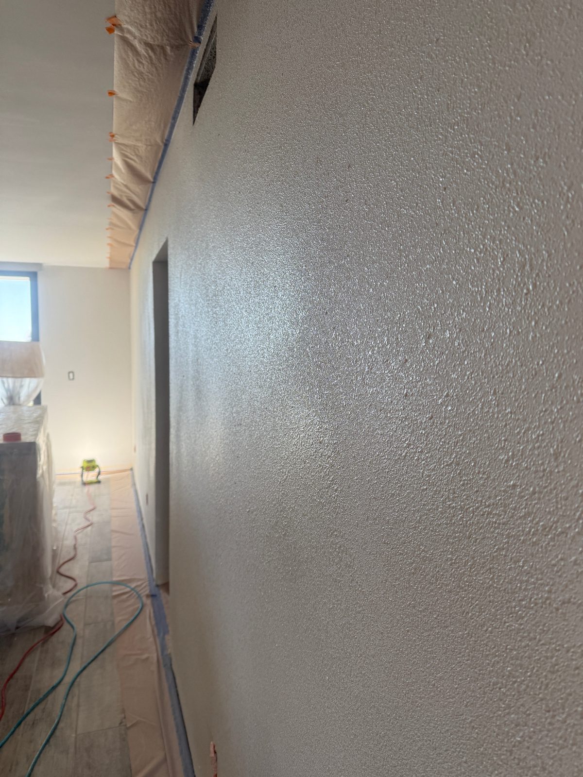 Knockdown-textured drywall repair in a Melbourne, FL hallway ready for paint