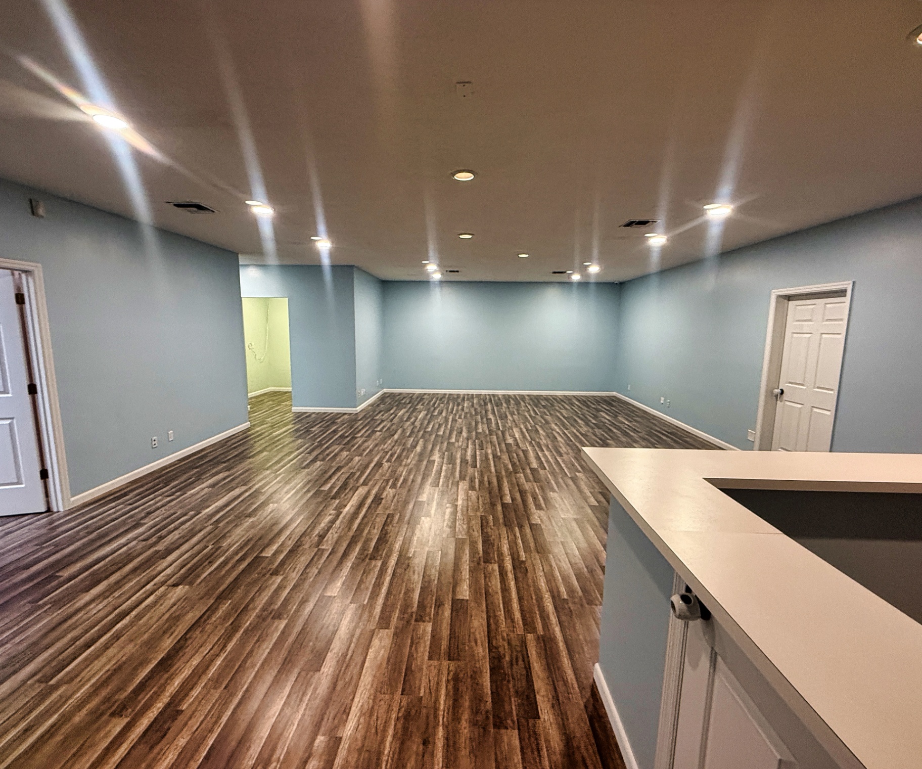Freshly painted soft-blue walls and bright white ceiling in a Melbourne, FL office space after repainting by Launch Painting Co.