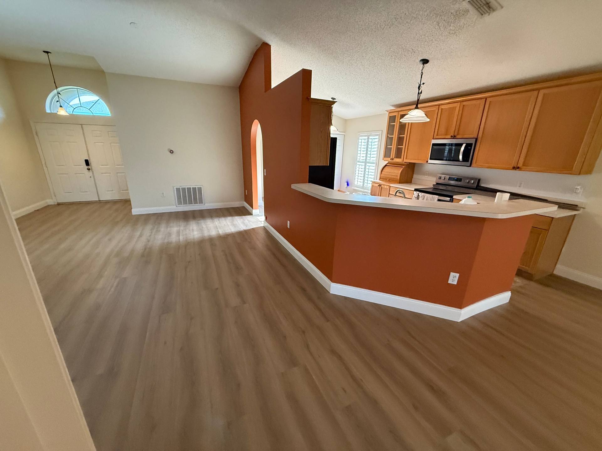 Freshly painted open-concept living room and kitchen interior with accent wall in a Melbourne, FL home